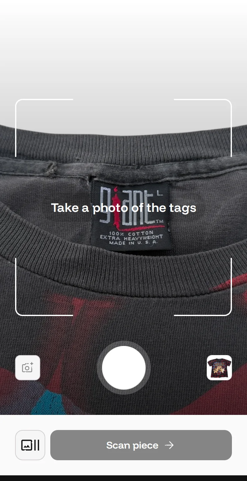 The Bidstitch camera aimed at the neck tag of a Nirvana Heart Shaped Box T-shirt, showing the woven Giant brand tag and its 100% cotton, extra heavyweight, made in U.S.A. text, prompting for a photo of the tags, with the scan button below.
